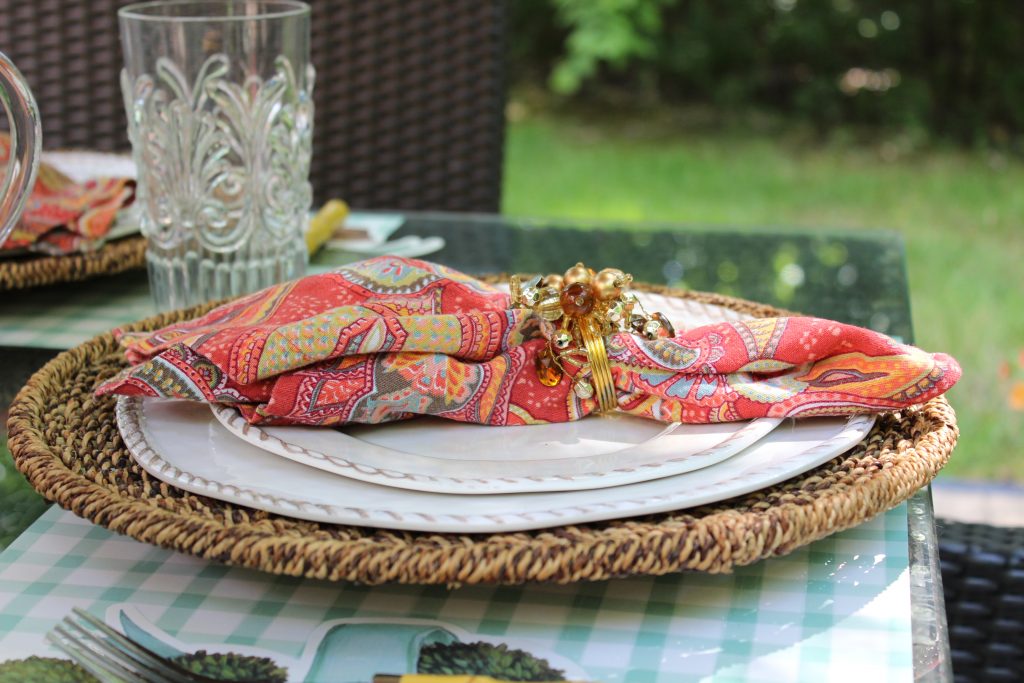 Hester and Cook placemat and place holder, Pottery Barn Tava Rattan Charger, Pottery Barn white rope melamine dinner plate, Pottery Barn Paisley print napkins, Pier 1 sparkle napkin rings, Neiman Marcus LeCadeaux Fleur Clear glass