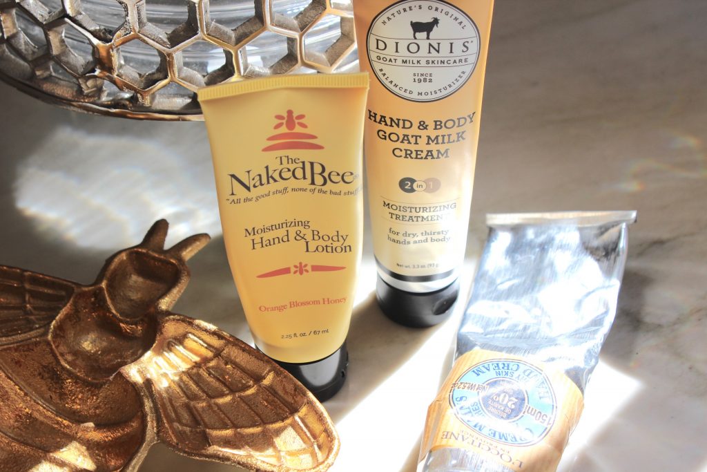 Tubes of hand cream by the naked bee, dionis, and l"occitane dry skin hand cream