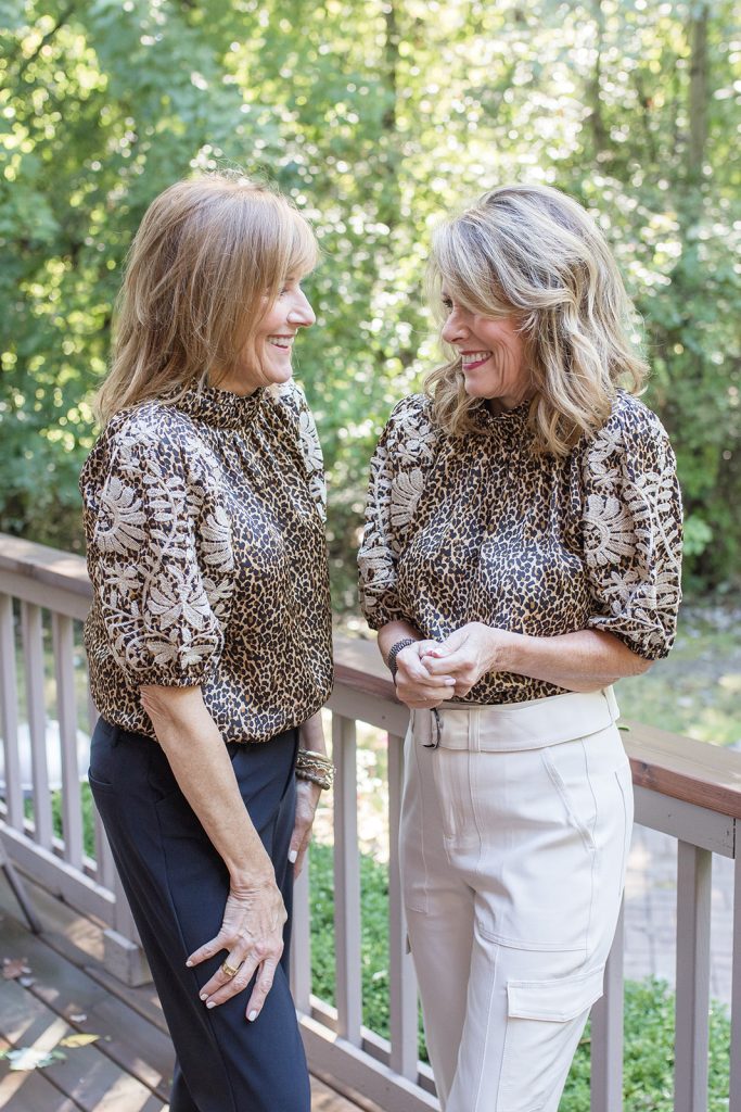 Leopard print short sleeved blouse shown with black pants and off white pants