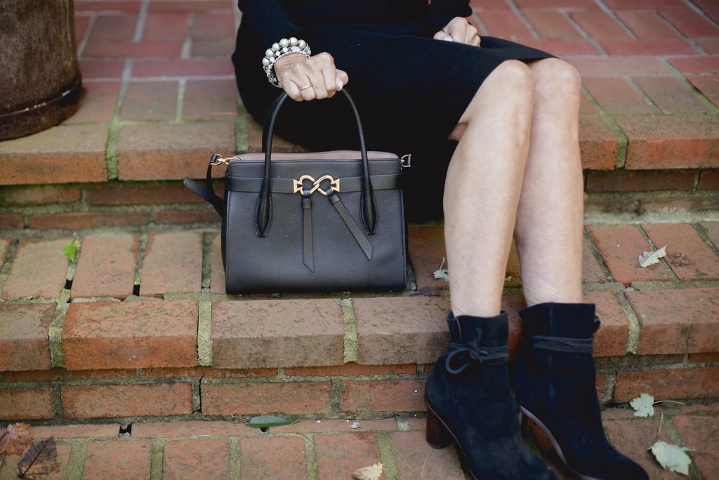 Val in booties, black purse and bracelet