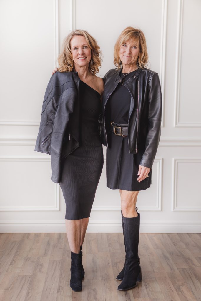 two women dressed in black dresses