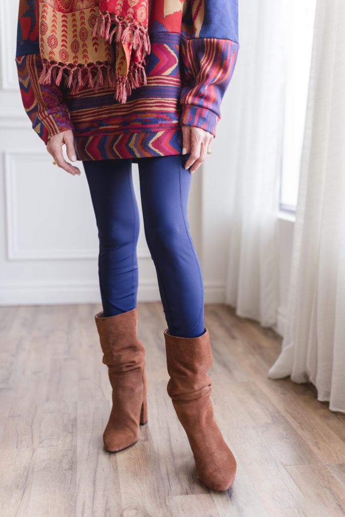 woman wearing colorful and vibrant sweater, leggings and boots